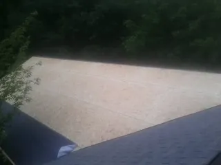 New OSB roof sheathing installed beside an existing shingle roof in Dayton